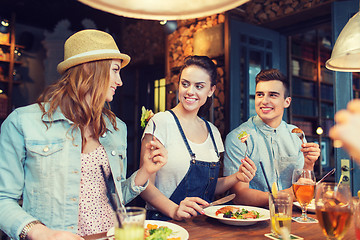 Image showing happy friends eating and drinking at bar or pub