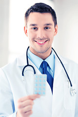 Image showing young male doctor with pack of pills