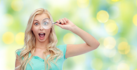 Image showing happy young woman with magnifying glass