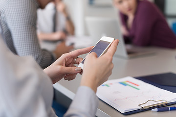 Image showing close up of  busineswoman hands  using smart phone on meeting