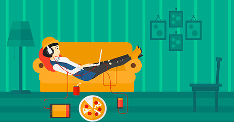 Image showing Woman lying on sofa with many gadgets.