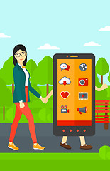 Image showing Woman walking with smartphone.