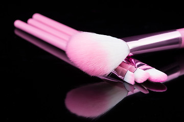 Image showing lipstick with a brush make-up on black 