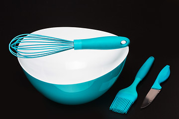 Image showing Green silicone pastry brush and soup plate isolated on black