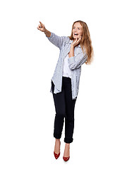 Image showing Happy excited woman in full length pointing to the side