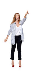 Image showing Happy excited woman in full length pointing to the side