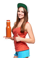 Image showing Happy teen girl holding a bottle of carrot juice