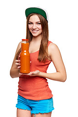 Image showing Happy teen girl holding a bottle of carrot juice