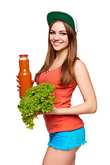 Image showing Happy teen girl holding a bottle of carrot juice