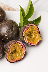 Image showing Passion fruits on white ceramic tray on wooden table background.