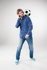 Image showing The portrait of fan with ball, holding phone on white background