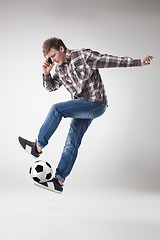 Image showing Portrait  of young man with smart phone and football ball