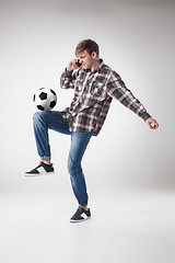 Image showing Portrait  of young man with smart phone and football ball