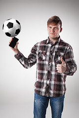 Image showing Portrait  of young man with smart phone and football ball