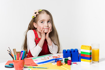 Image showing Cute little girl drawing with paint and paintbrush at home