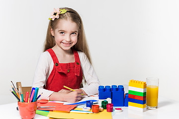 Image showing Cute little girl drawing with paint and paintbrush at home