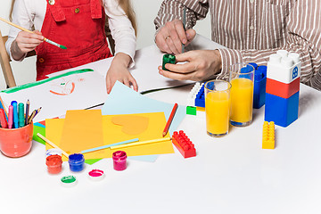 Image showing The daughter and father carving out paper applications 