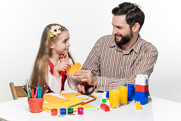 Image showing The daughter and father carving out paper applications 