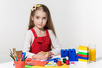 Image showing Cute little girl drawing with paint and paintbrush at home