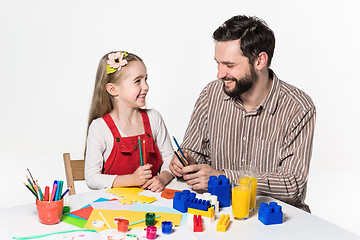 Image showing The daughter and father carving out paper applications 