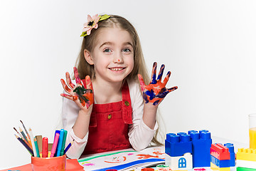 Image showing The beautiful little girl with hands in the paint