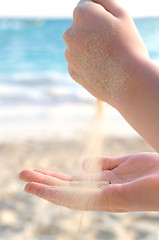 Image showing Hands pouring sand on a beach