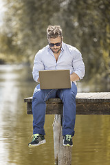 Image showing man at the lake with notebook