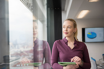 Image showing blonde businesswoman working on tablet at office