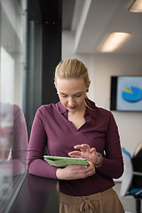 Image showing blonde businesswoman working on tablet at office