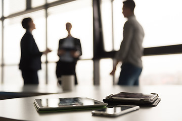 Image showing close up of tablet, business people on meeting in background