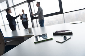 Image showing close up of tablet, business people on meeting in background