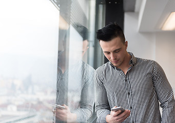 Image showing young business man using smart phone at office