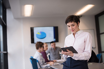 Image showing hispanic businesswoman with tablet at meeting room