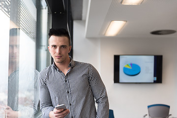 Image showing young business man using smart phone at office