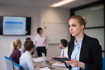 Image showing business woman working on tablet at meeting room