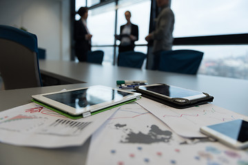 Image showing close up of tablet, business people on meeting in background