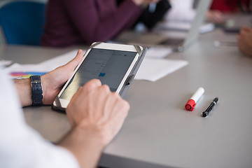 Image showing close up of  businessman hands  using tablet on meeting