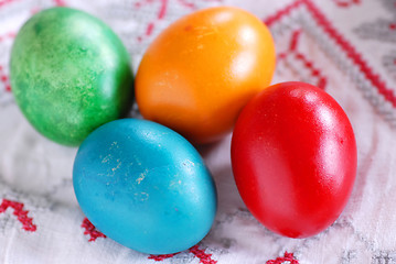 Image showing Four colorful easter eggs on linen tablecloth