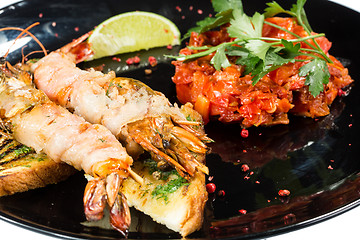 Image showing perfect dish with shrimps on a black plate. seafood