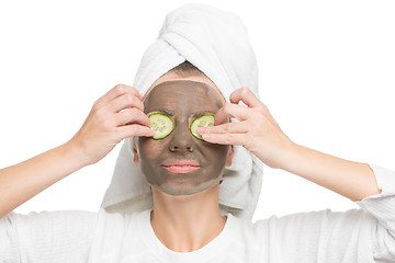 Image showing Young beautiful woman in mask for the face. therapeutic black clay. Spa treatment.