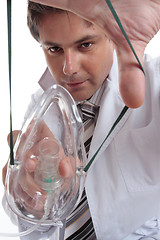 Image showing Doctor applying mask to patient