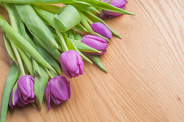 Image showing Violet tulips, cake and tea on the wood