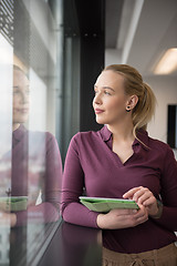 Image showing blonde businesswoman working on tablet at office