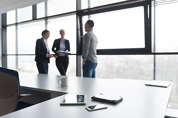 Image showing close up of tablet, business people on meeting in background