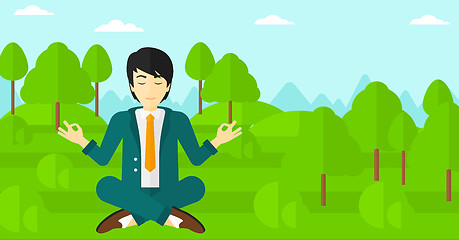 Image showing Businessman meditating in lotus pose.