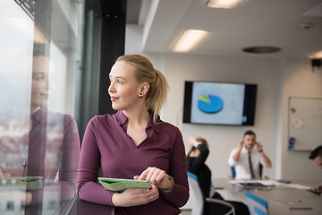 Image showing blonde businesswoman working on tablet at office