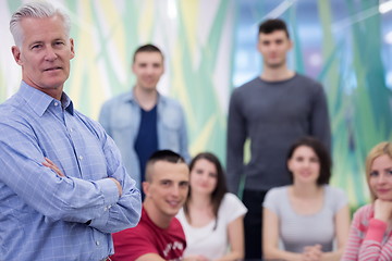 Image showing portrait of  teacher with students group in background