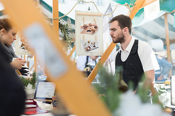 Image showing Man serving street food on international cuisine event in Ljubljana, Slovenia.