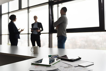 Image showing close up of tablet, business people on meeting in background