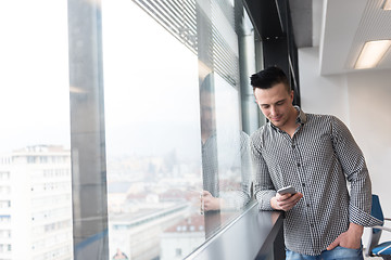 Image showing young business man using smart phone at office